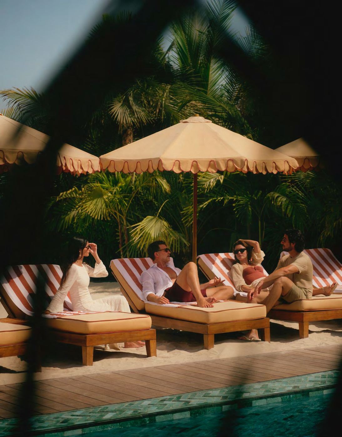 Guests relaxing on loungers beside the pool